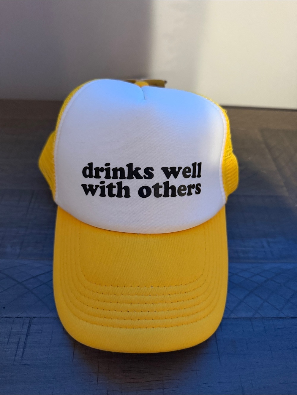 Yellow and White Trucker Hat with 'drinks well with others'